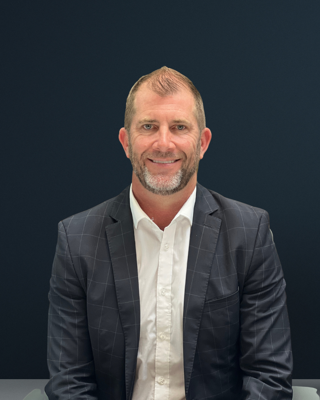 Man in suit against dark background.